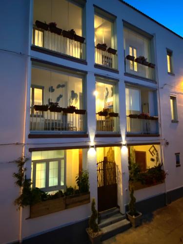 a white building with windows and balconies at night at Canduleri in Orgosolo
