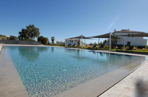 una piscina en un complejo con agua azul en Quinta do Algarvio Village, en Carvoeiro