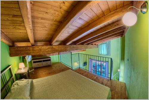 a bedroom with green walls and a wooden ceiling at Fantastica Casa Poppo in Bellano