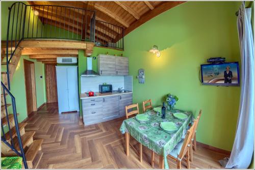 a dining room with a table and a kitchen at Fantastica Casa Poppo in Bellano
