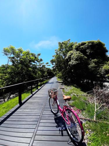 台東市的住宿－愛旅民宿 ，木板路上的粉红色自行车