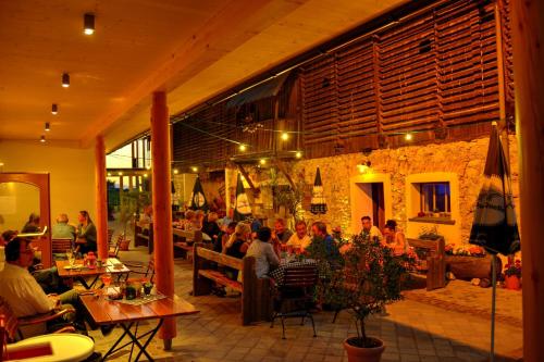 un grupo de personas sentadas en mesas en un restaurante en Alpen Adria Gasthof Rausch, en Ledenitzen