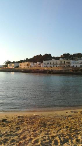 ein Wasserkörper mit Gebäuden und einem Strand in der Unterkunft Casa vacanza Salento, Santa Maria al Bagno in Galatone