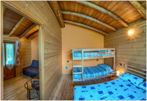 a bedroom with bunk beds in a wooden house at Fantastica Casa Poppo in Bellano