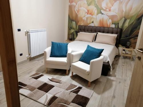 a bedroom with a bed and two chairs at DoSe di relax in Casertavecchia