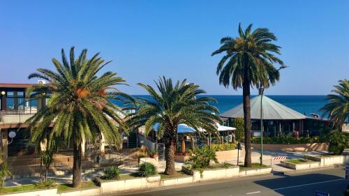 a group of palm trees in front of a building at Hotel Serena in Arenzano