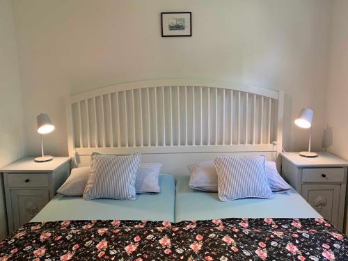 ein Schlafzimmer mit einem großen Bett mit zwei Nachttischen in der Unterkunft Ferienwohnung Alte Fehnapotheke, 95144 in Rhauderfehn