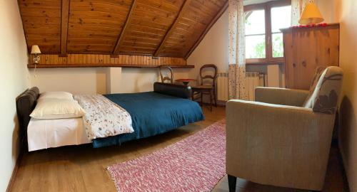 a bedroom with a bed and a chair and a table at Agroturystyka u Królów in Nowe Guty