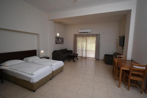 a bedroom with a bed and a table and a couch at Kibbutz Tiratzvi - Country Lodging in Tirat Ẕevi