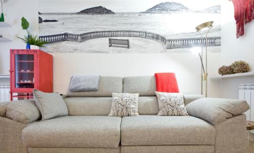 a couch in a living room with a picture of a bridge at City EPI-CENTER in San Sebastián