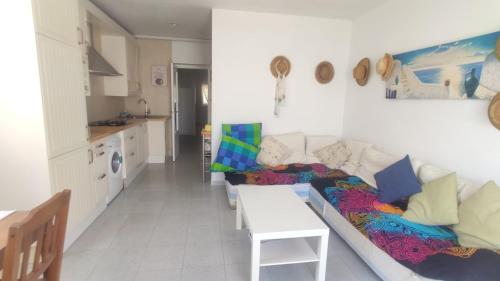 ein Wohnzimmer mit einem Sofa und einer Küche in der Unterkunft Mi morena cala llobeta 35 in L'Ametlla de Mar