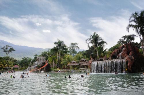 a pool at a water park with a waterfall at Hotel Felda Residence Hot Springs in Sungkai