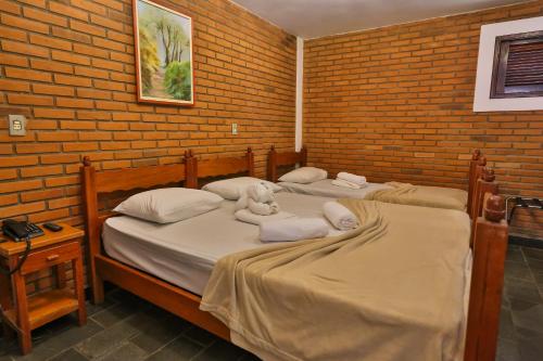 two beds in a room with stuffed animals on them at Hotel Fazenda Campo dos Sonhos in Socorro
