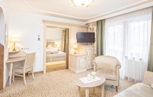 a hotel room with a bed and a table and chairs at Der Lärchenhof in Erpfendorf