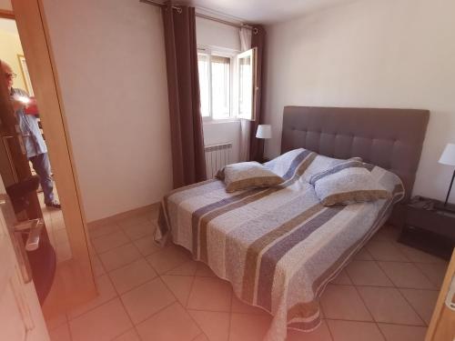 une chambre avec un lit avec deux oreillers dessus dans l'établissement Ou Souleou, à Bormes-les-Mimosas