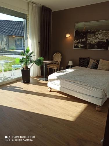 a bedroom with a bed and a large window at Hotel Fleur de Lys in Bailleul