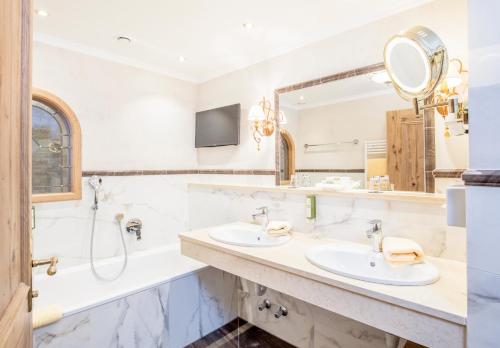 a bathroom with two sinks and a large mirror at Der Lärchenhof in Erpfendorf