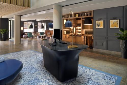 a lobby with a black desk in a room at Mövenpick Hotel The Hague in The Hague