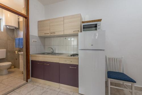 eine Küche mit einem weißen Kühlschrank und einer Spüle in der Unterkunft Apartmani Mlinar9 #1 in Gornji Karin