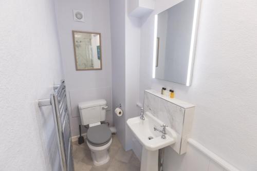 a white bathroom with a toilet and a sink at The Old Vicarage Hotel & Restaurant in Bridgwater
