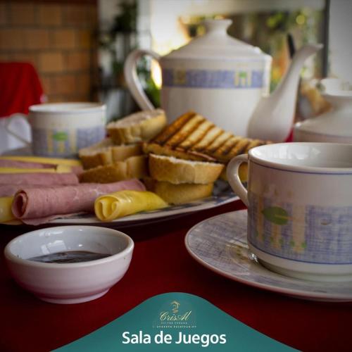 J. Saldivar的住宿－CrisAl Suite Posada，餐桌,带两盘食物和一杯咖啡的桌子