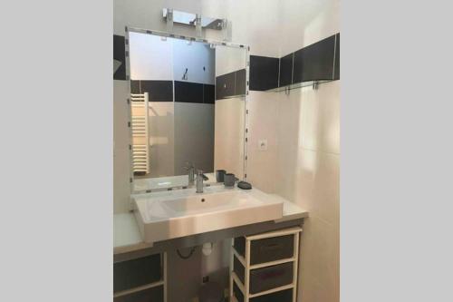 ein Badezimmer mit Waschbecken und Spiegel in der Unterkunft Villa bord de mer in Torreilles