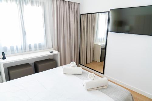 Cette chambre comprend un lit et un grand miroir. dans l'établissement HOTEL SON VILAR, à Es Castell