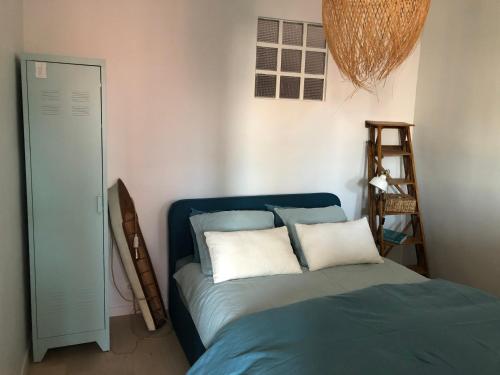 - une chambre avec un lit bleu et 2 oreillers dans l'établissement L’Erso, à La Ciotat