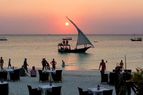 a group of people on the beach with a sail boat at Z Hotel & Z2 Hotel in Nungwi