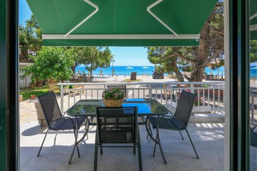 a patio with a table and chairs and the ocean at Agapitos Apartments in Nikiti