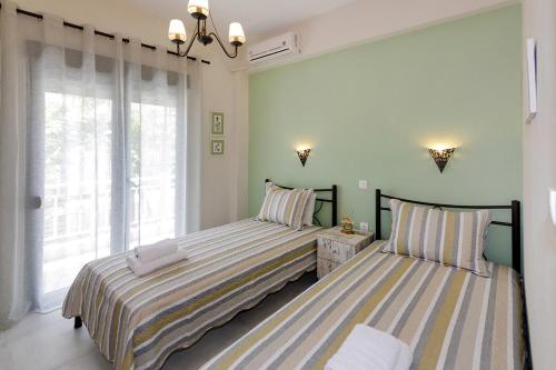two beds sitting next to each other in a bedroom at Agapitos Apartments in Nikiti