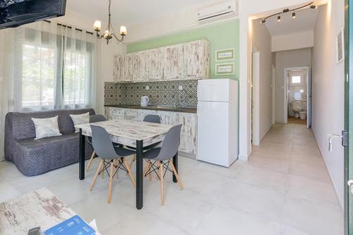a kitchen and dining room with a table and a refrigerator at Agapitos Apartments in Nikiti