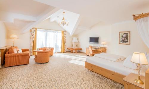a bedroom with a bed and a living room at Der Lärchenhof in Erpfendorf