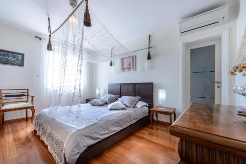 a bedroom with a bed and a wooden floor at Villa Residence Lantoni in Mlini