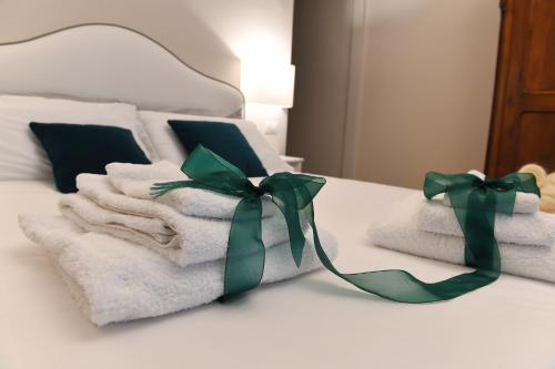 a pile of towels with green bows on a bed at Attico 195 in Salerno