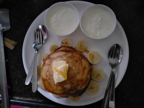 a plate of food with pancakes with butter and bananas at Bansi Niwas in Udaipur