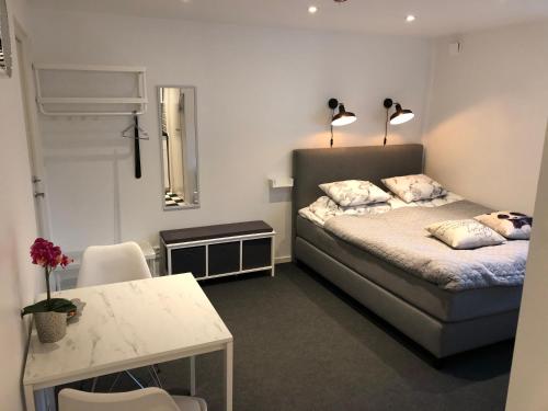 a bedroom with a bed and a table and two lamps at Smultronstallet Gårdshotell in Valleberga