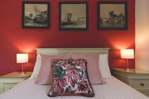 a bedroom with red walls and a bed with a pillow at The Old Vicarage Hotel & Restaurant in Bridgwater