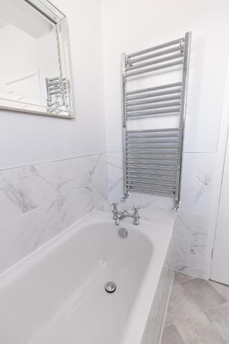 a white bath tub in a bathroom with a mirror at The Old Vicarage Hotel & Restaurant in Bridgwater