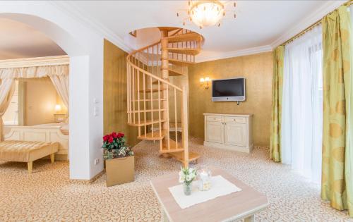 a living room with a spiral staircase and a bedroom at Der Lärchenhof in Erpfendorf