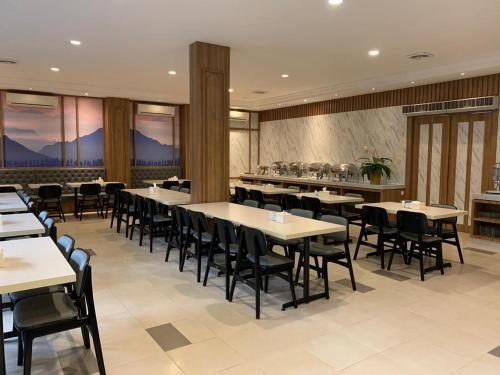 a restaurant with tables and chairs and a bar at Bintang Mulia Hotel & Resto in Jember