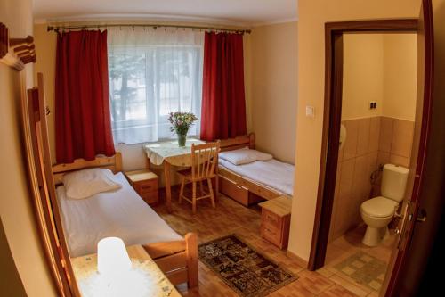 Cette chambre comprend 2 lits, une table et une fenêtre. dans l'établissement Hostel Rest, à Cracovie