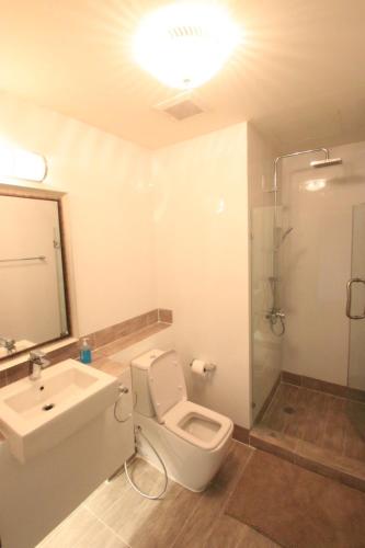 a bathroom with a toilet and a sink and a shower at Baan Rub Lom by Jane in Pak Chong