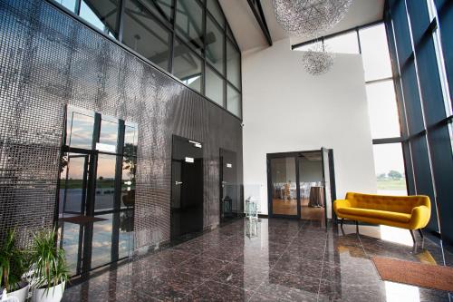 a lobby with a yellow couch in a building at Hotel Węgierki in Września