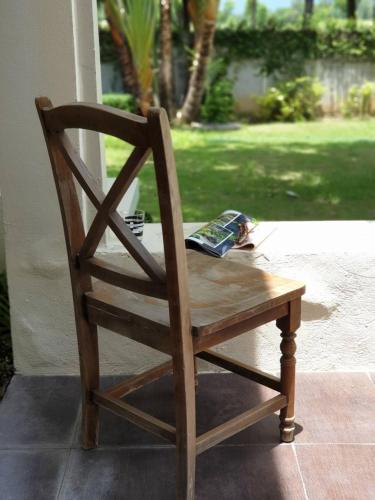 a wooden chair sitting in front of a porch at Baan Rub Lom by Jane in Pak Chong