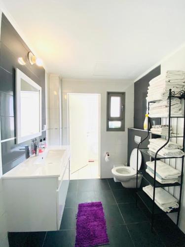 a bathroom with a sink and a toilet and a tub at Stunning Penthouse with sea views and private heated pool in Eilat