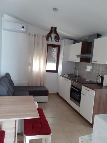 a kitchen and living room with a table and a couch at Apartman Mara in Vir