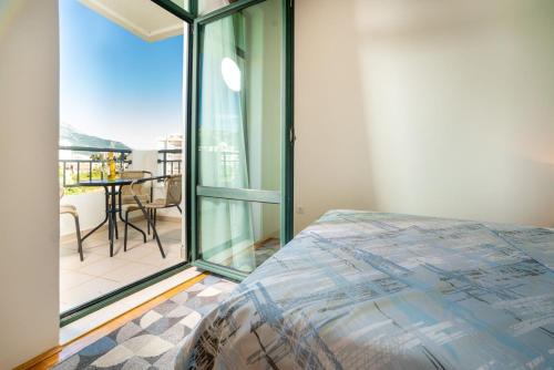 a bedroom with a bed and a balcony with a table at Apartment Hanja in Bar
