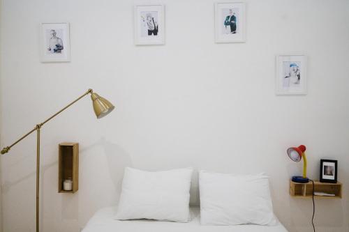a bedroom with white walls and a bed with white pillows at Cosy and Modern Flat in Porto in Porto
