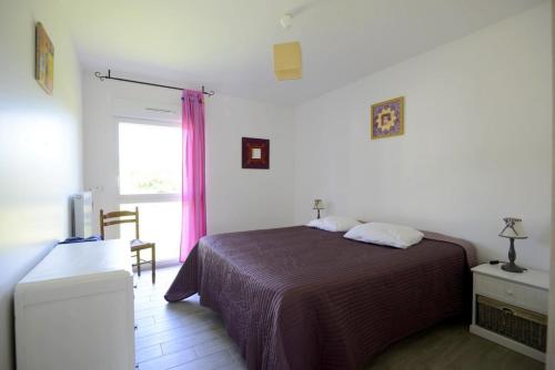 um quarto com uma cama e uma janela em Fleur de Lys em Mer